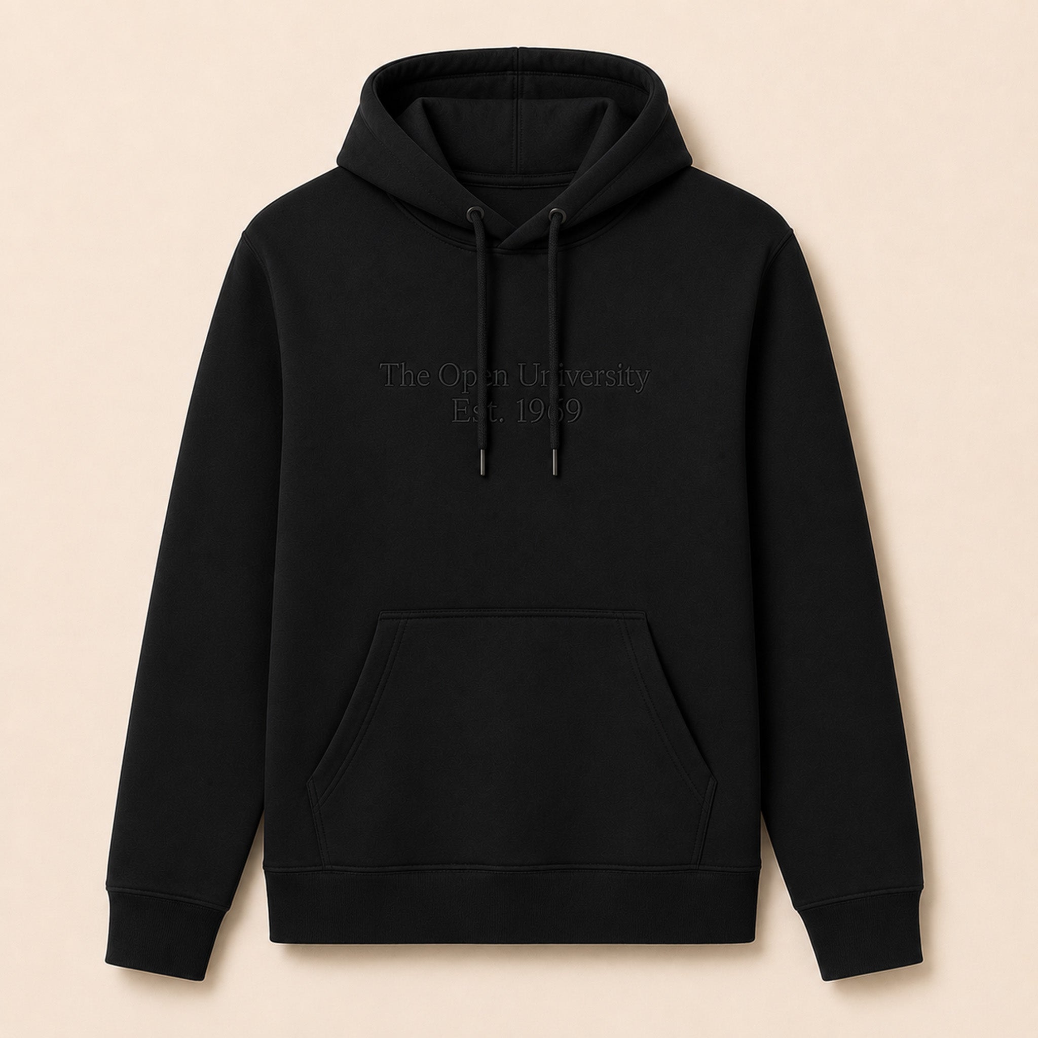 A black pullover hoodie with tonal embroidered text reading 'The Open University Est. 1969' on the chest, displayed against a solid light beige background.