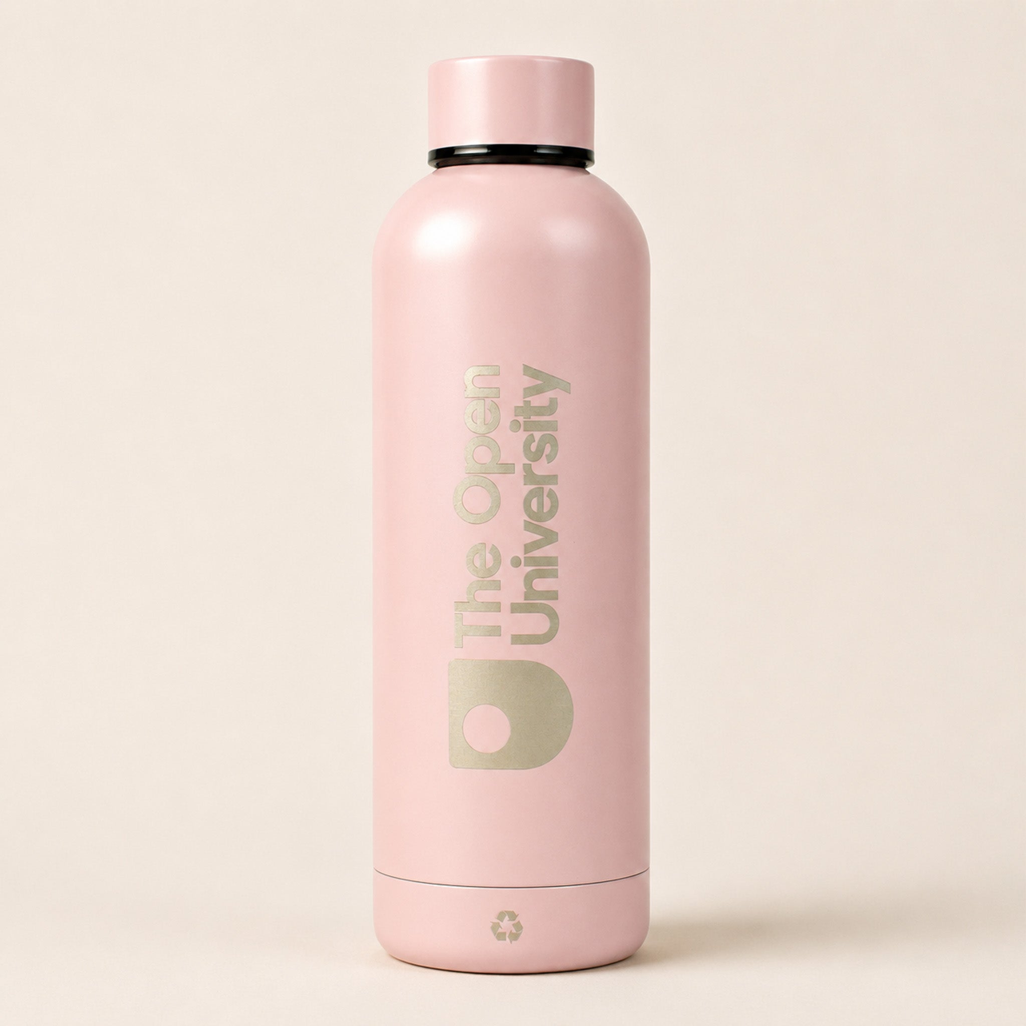 A matte light pink insulated water bottle with a matching pink cap, featuring 'The Open University' printed vertically in a muted sage green on the front, set against a solid light beige background.